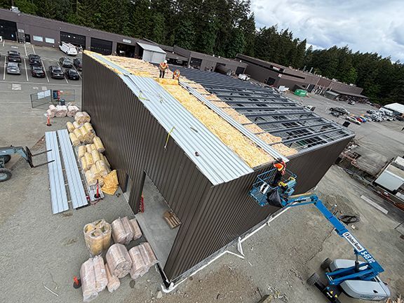 Metal roof panels being added to commercial building project