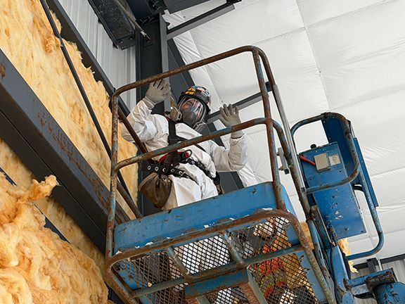 Construction worker in safety gear installing insulation 