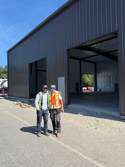 John Lohan stands in front of a completed metal building project