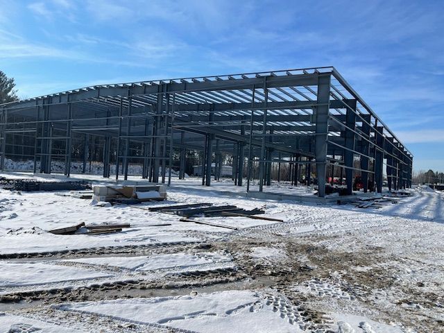 A large metal structure is being built in the snow.