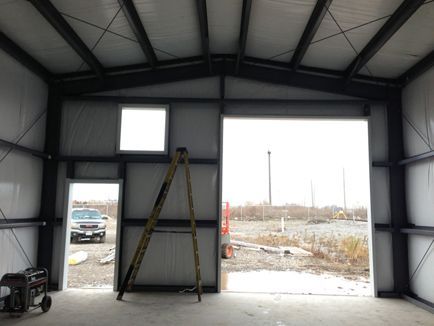A ladder is sitting inside of a building with the door open