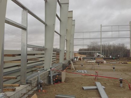 A large metal structure is being built on a cloudy day.