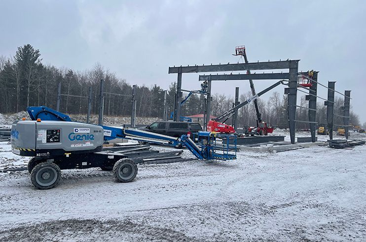 A construction site with a lot of machinery in the snow.