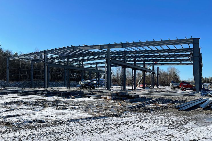 A large metal structure is being built in a snowy field.