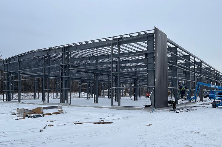 A large metal structure is being built in the snow.