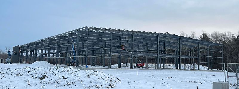 A large metal structure is being built in the snow.