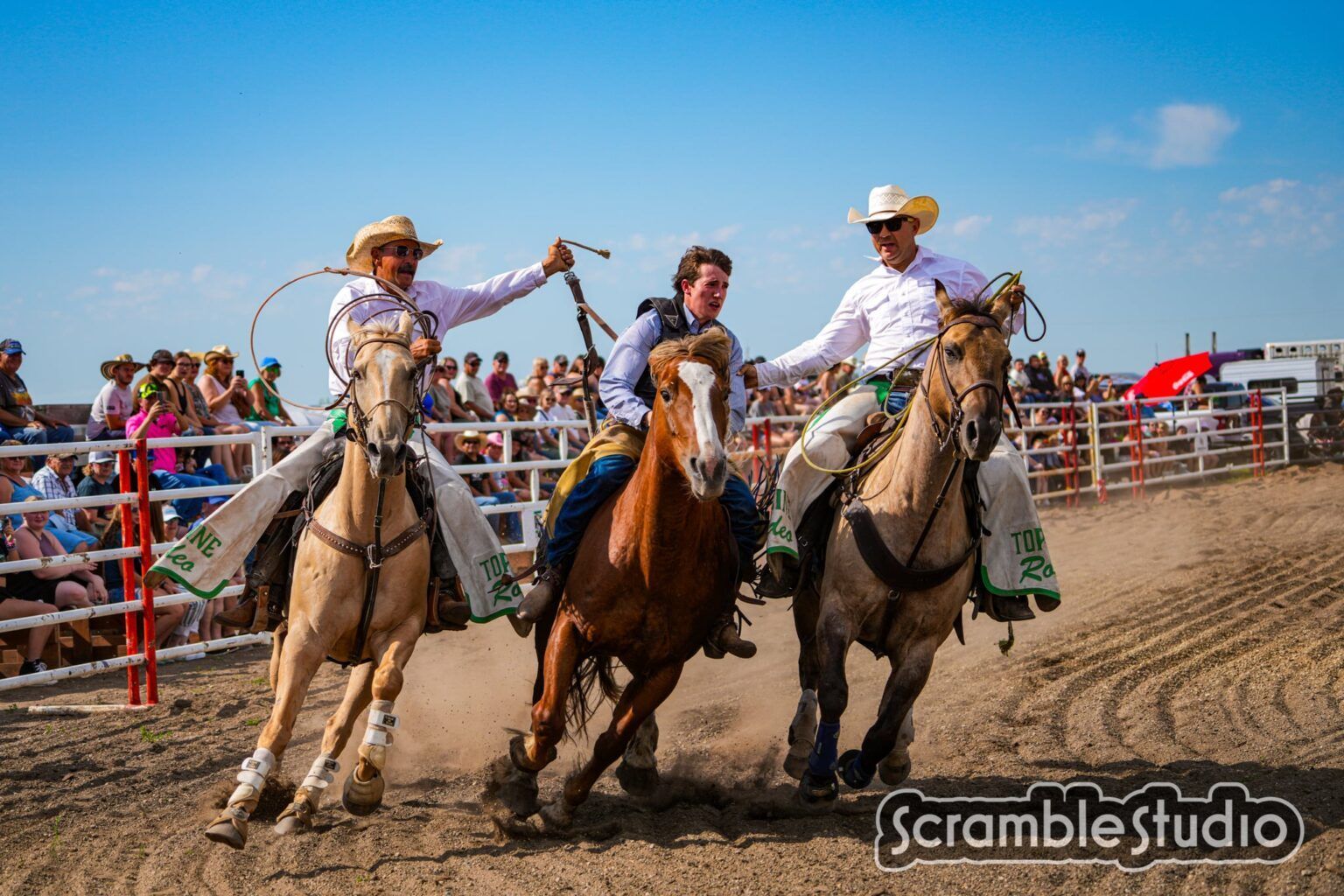 Two cowboys assist a rider in the 2025 Waywayseecappo rodeo.