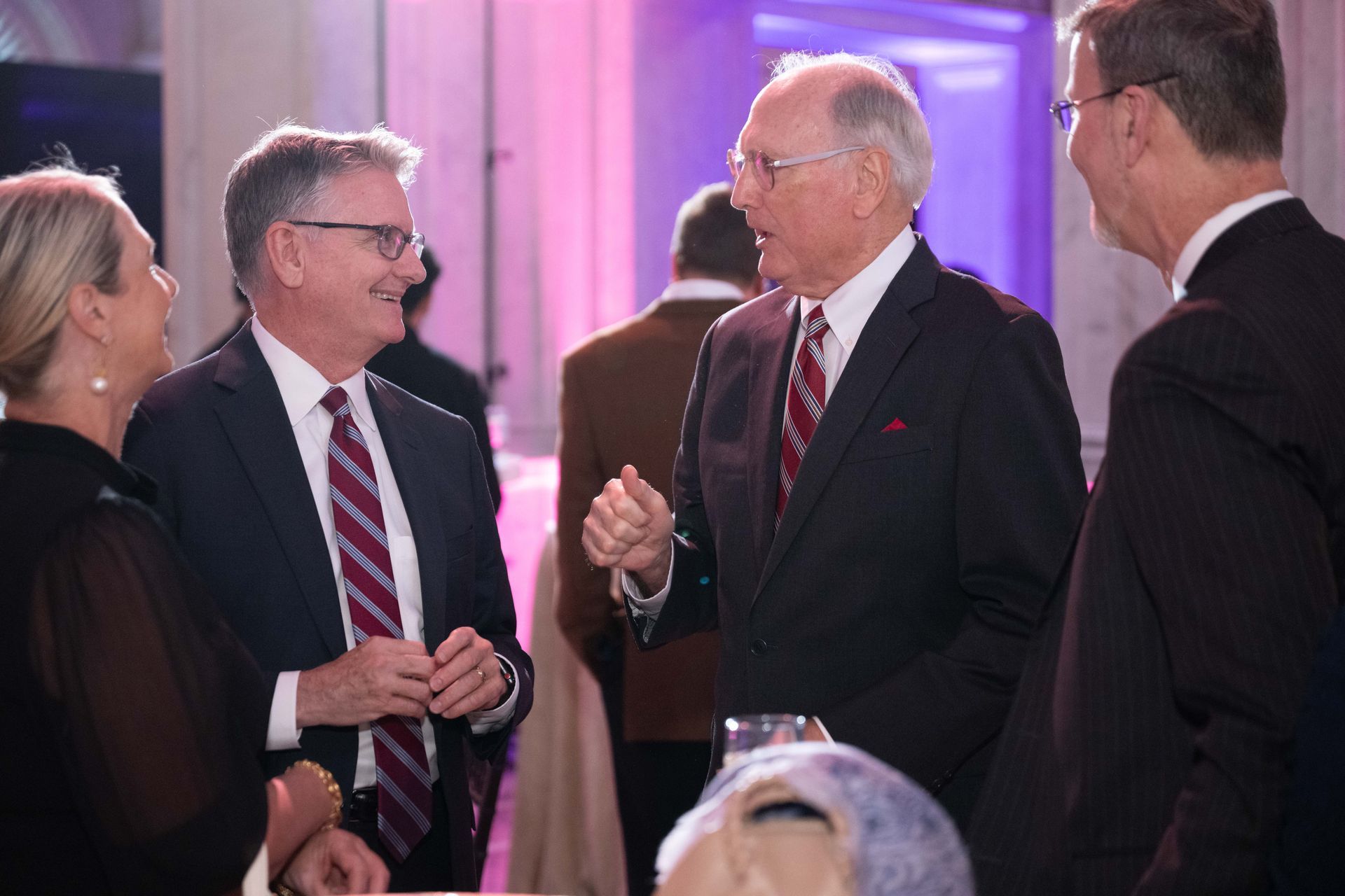 A group of men in suits and ties are talking to each other