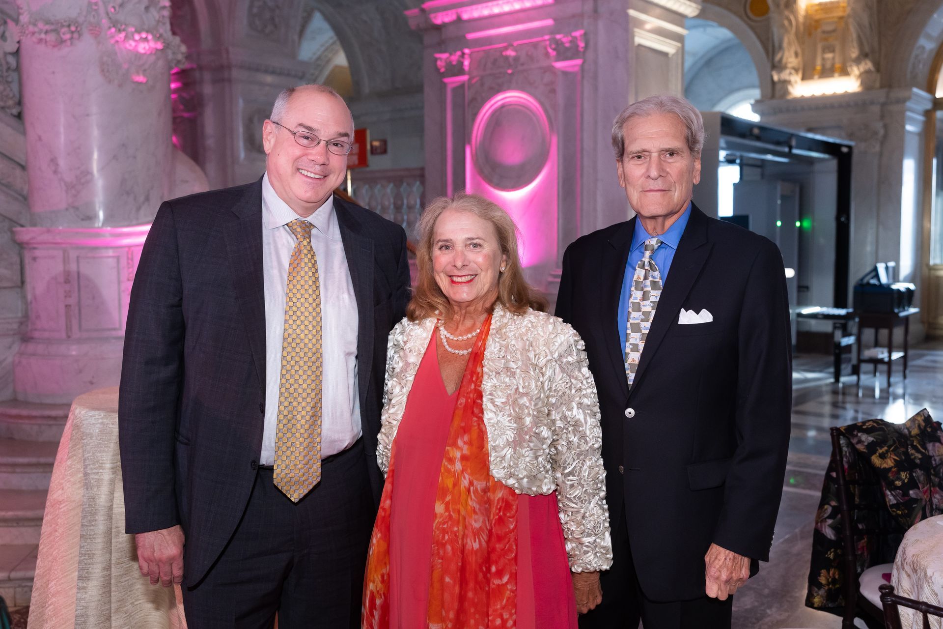 Three people in suits and ties are posing for a picture.
