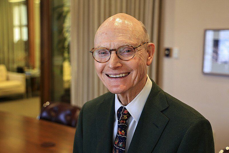 A man in a suit and tie is smiling for the camera.