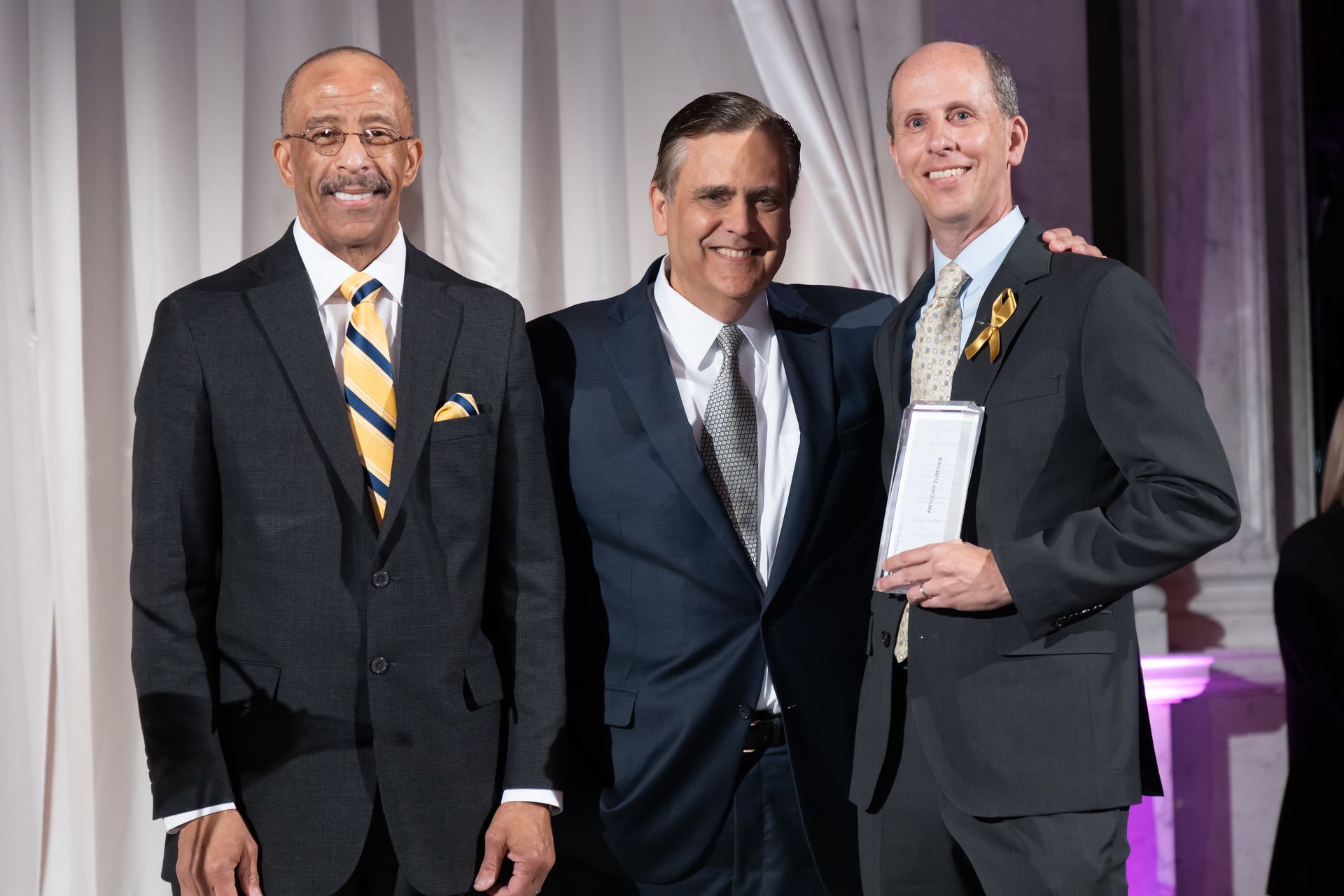 Three men in suits and ties are posing for a picture