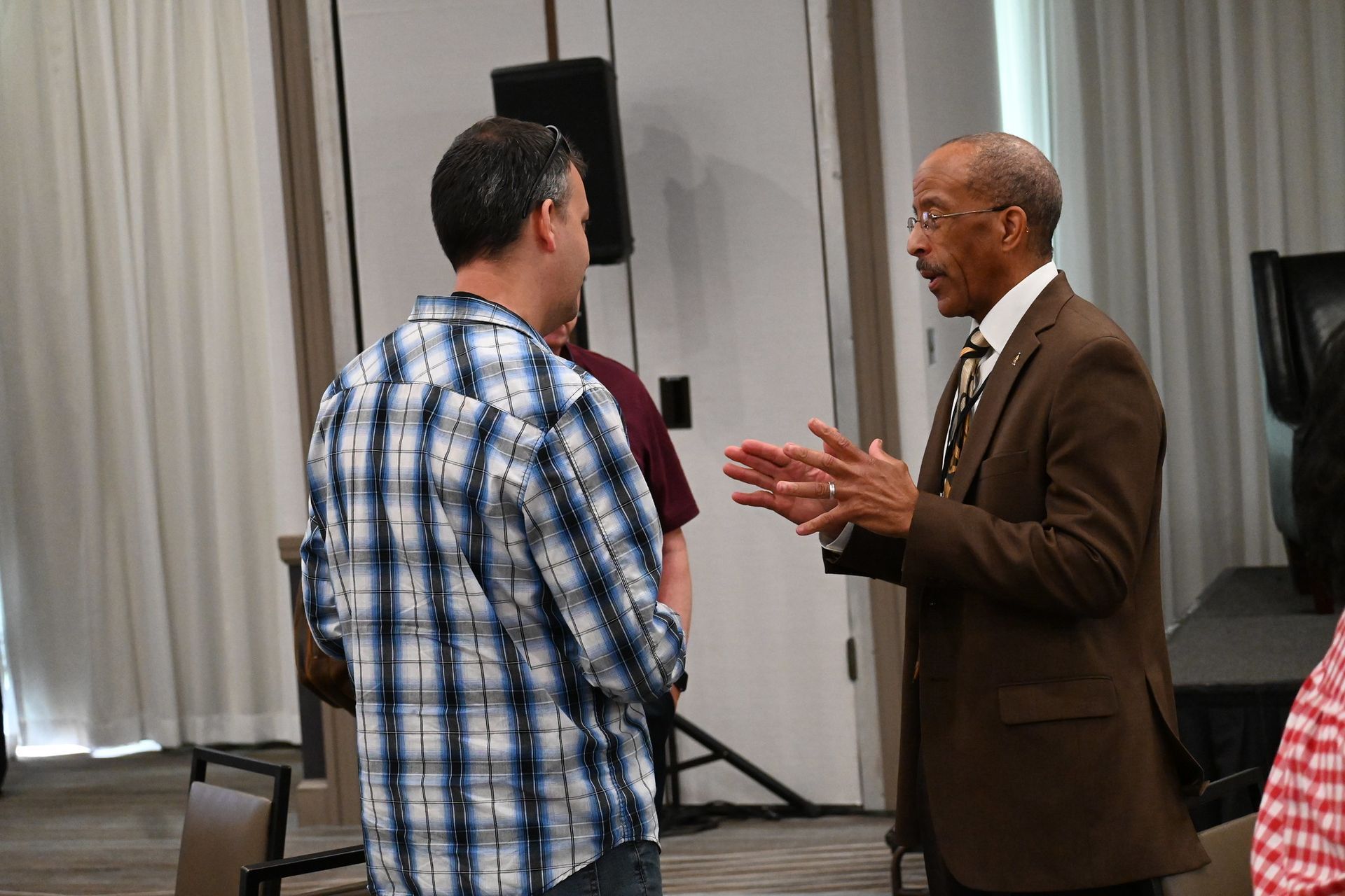 Two men are talking to each other in a room.