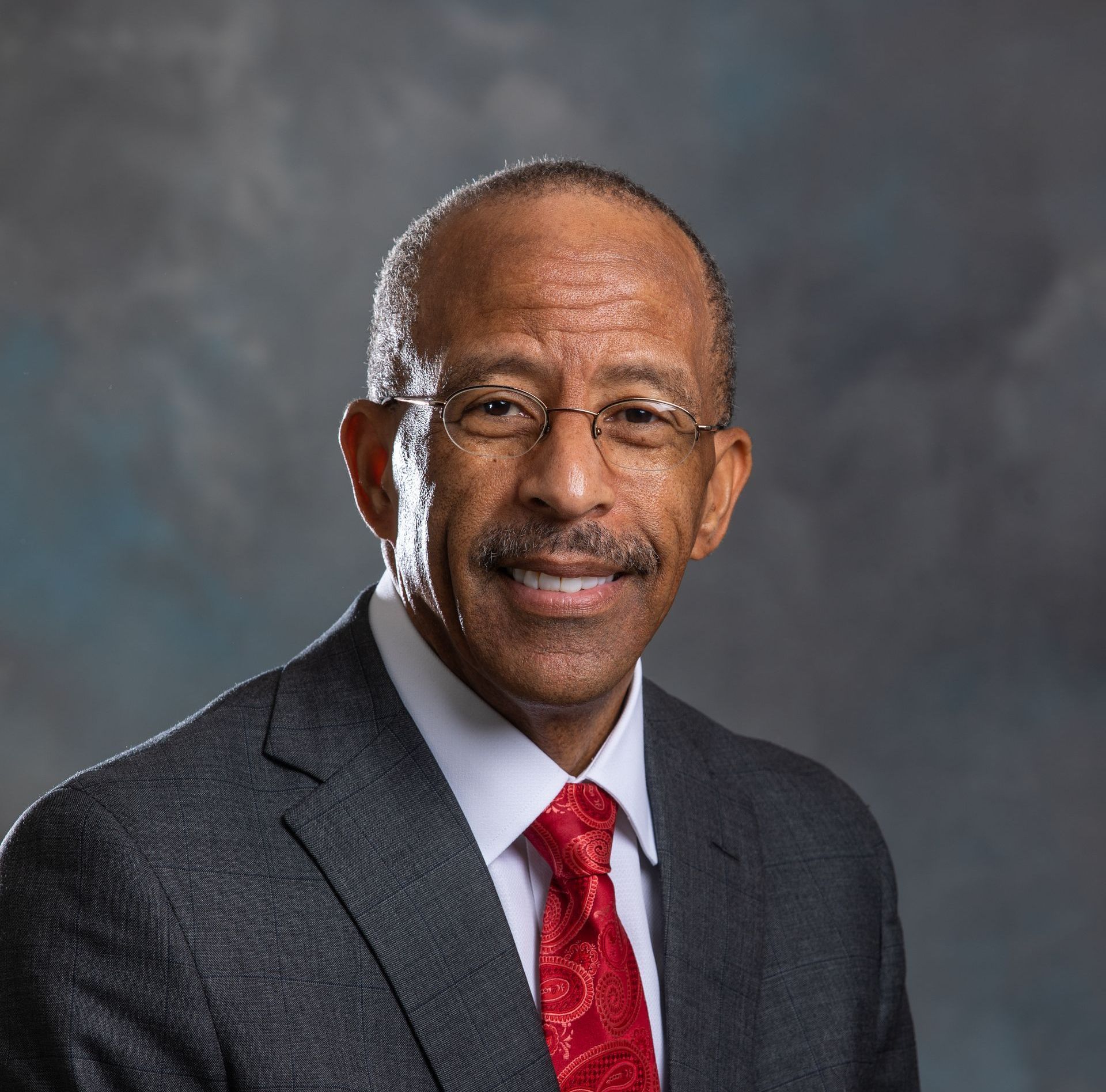A man in a suit and tie is smiling for the camera
