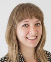 A woman with blonde hair and bangs is smiling for the camera