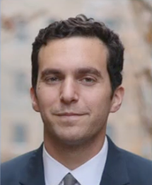 A man in a suit and tie is smiling for the camera.