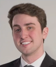 A man in a suit and tie is smiling for the camera