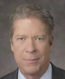 A man in a suit and tie is smiling for the camera.