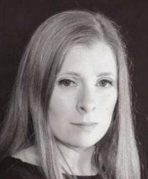 A woman with long hair is looking at the camera in a black and white photo.