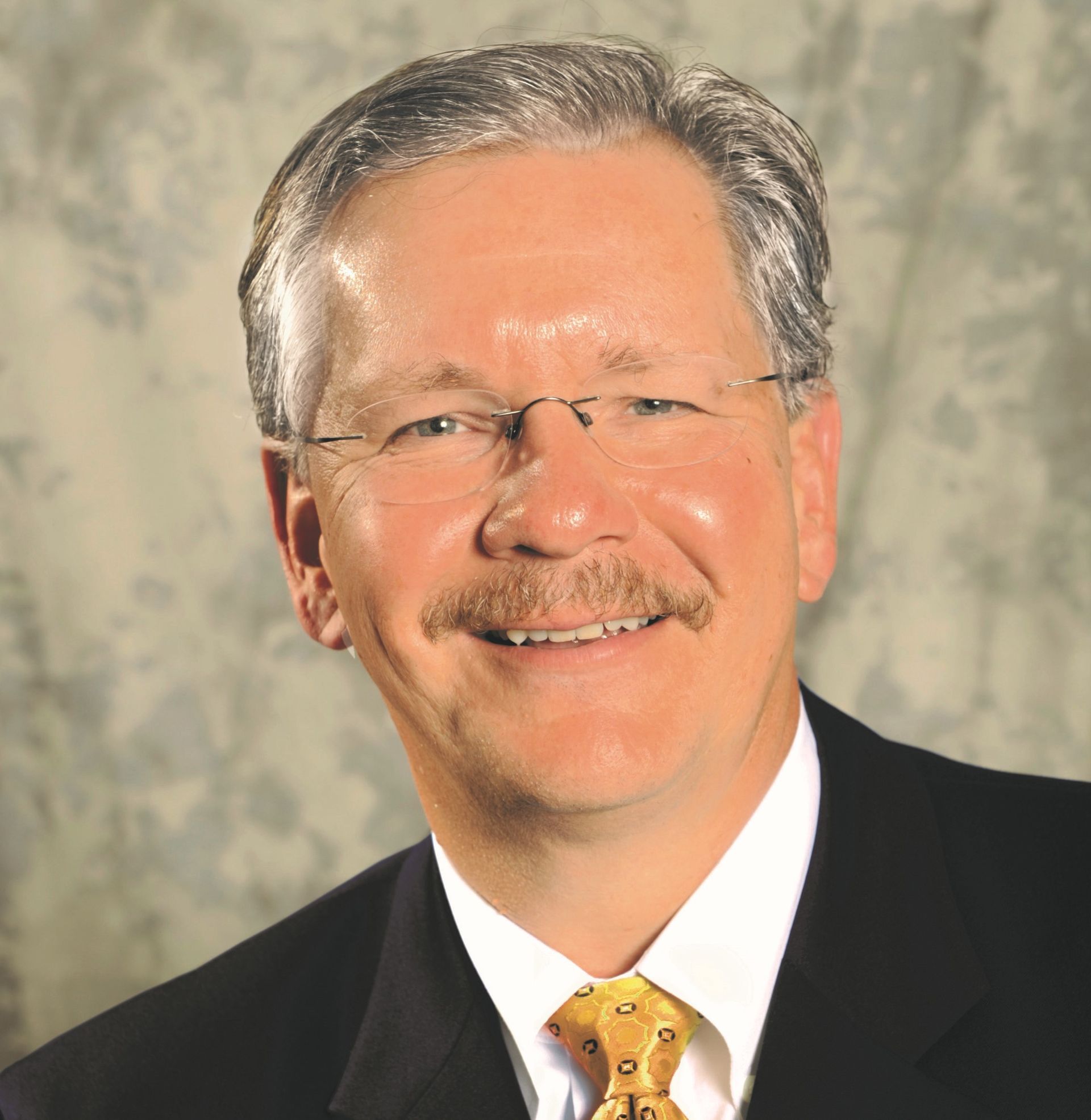 A man in a suit and tie smiles for the camera