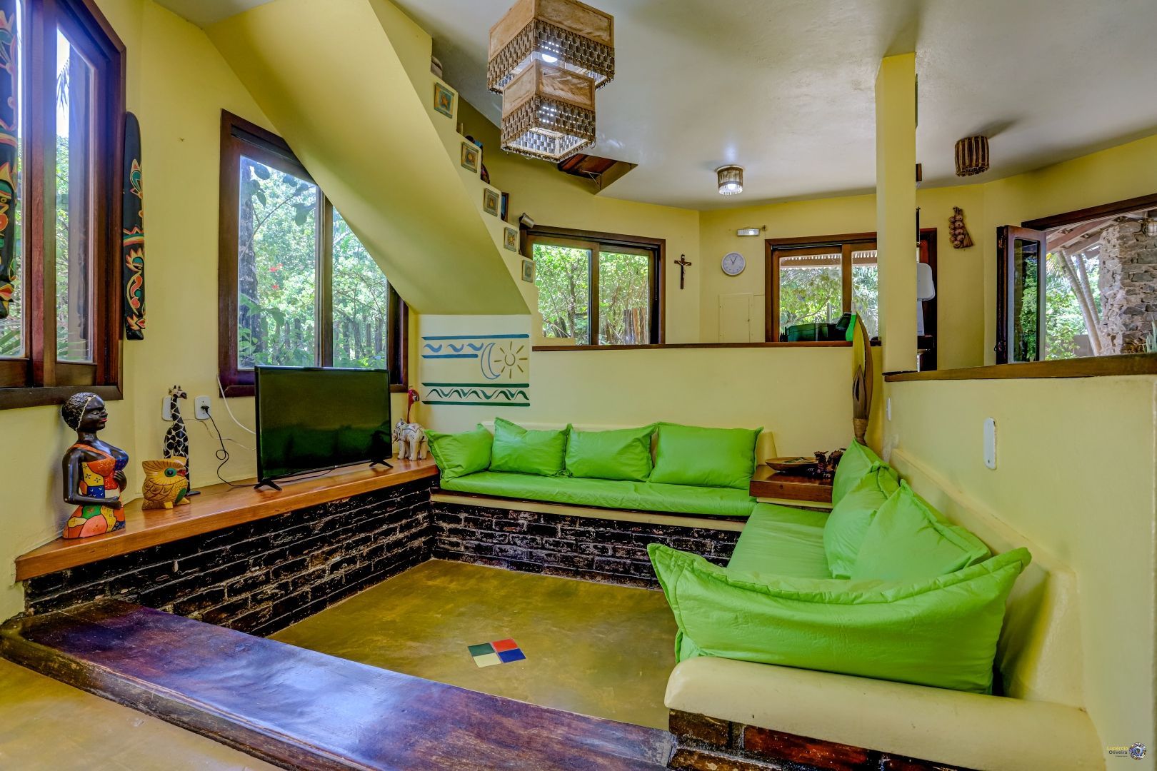 Uma sala de estar com um sofá verde e escadas.