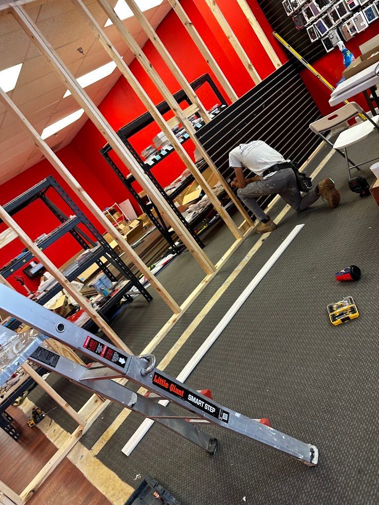 A man is kneeling down in a room with a ladder that says ' ladder ' on it