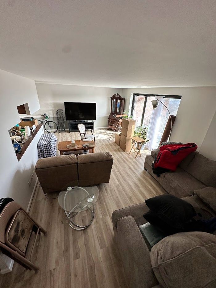 Bright living room with sofa, TV, coffee table, and sliding glass door to a patio