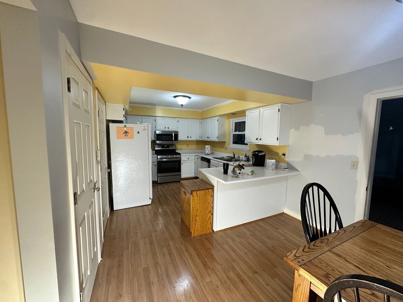 A kitchen with a table and chairs and a refrigerator.