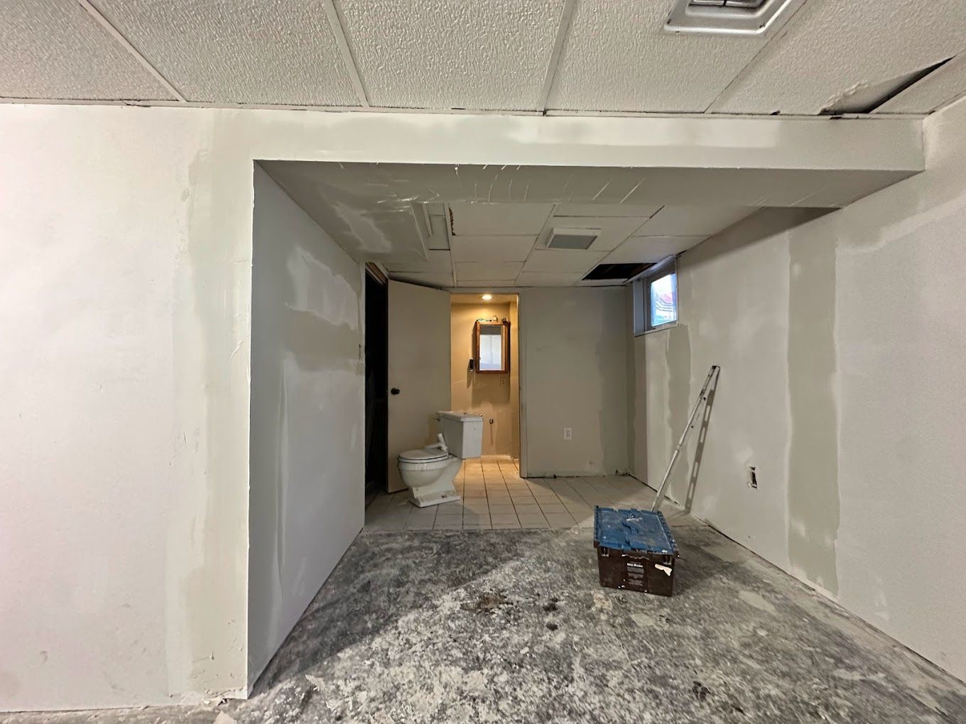 A room with a toilet and a box on the floor.