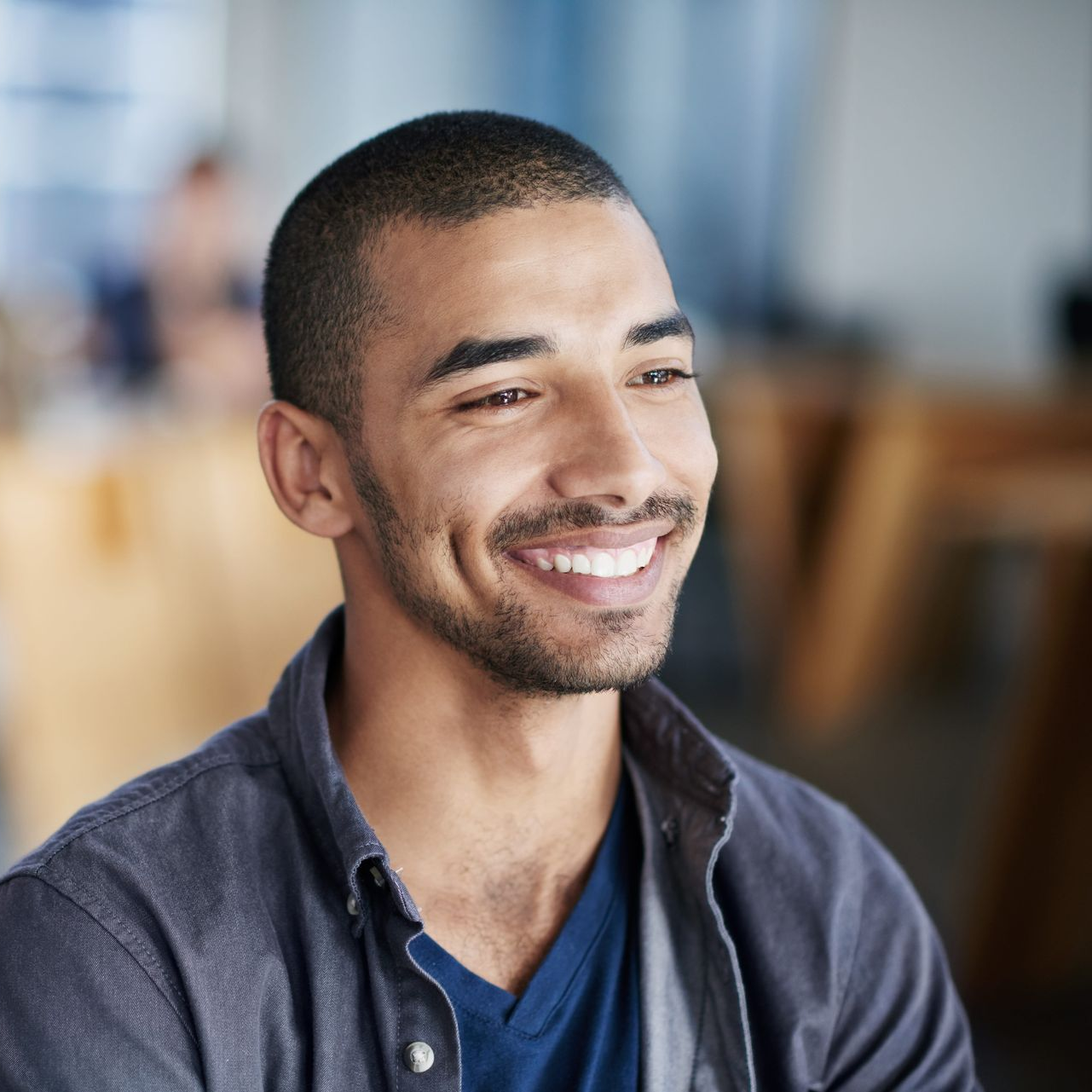 Smiling man in a blue shirt in a bright office setting