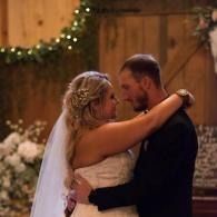 Bride and groom embracing and dancing at a warmly lit wedding reception