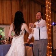 Bride and groom dancing at a wedding reception under string lights