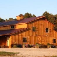 Orange wooden barn with a red roof in a sunny rural setting
