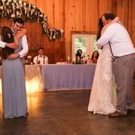 Two couples slow dancing at a wedding reception in a wood-paneled hall