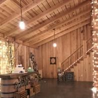 Wooden cabin interior with staircase, hanging lights, and rustic decor near a counter