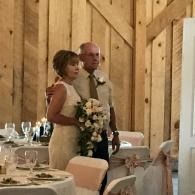 Bride and groom standing together at a reception table in a wood-paneled venue