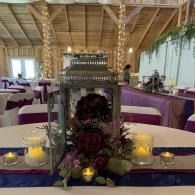 Decorated banquet table with candles and floral centerpiece in a rustic reception hall