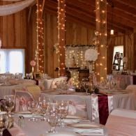 Elegant wood-paneled wedding reception hall with white table settings and soft string lights