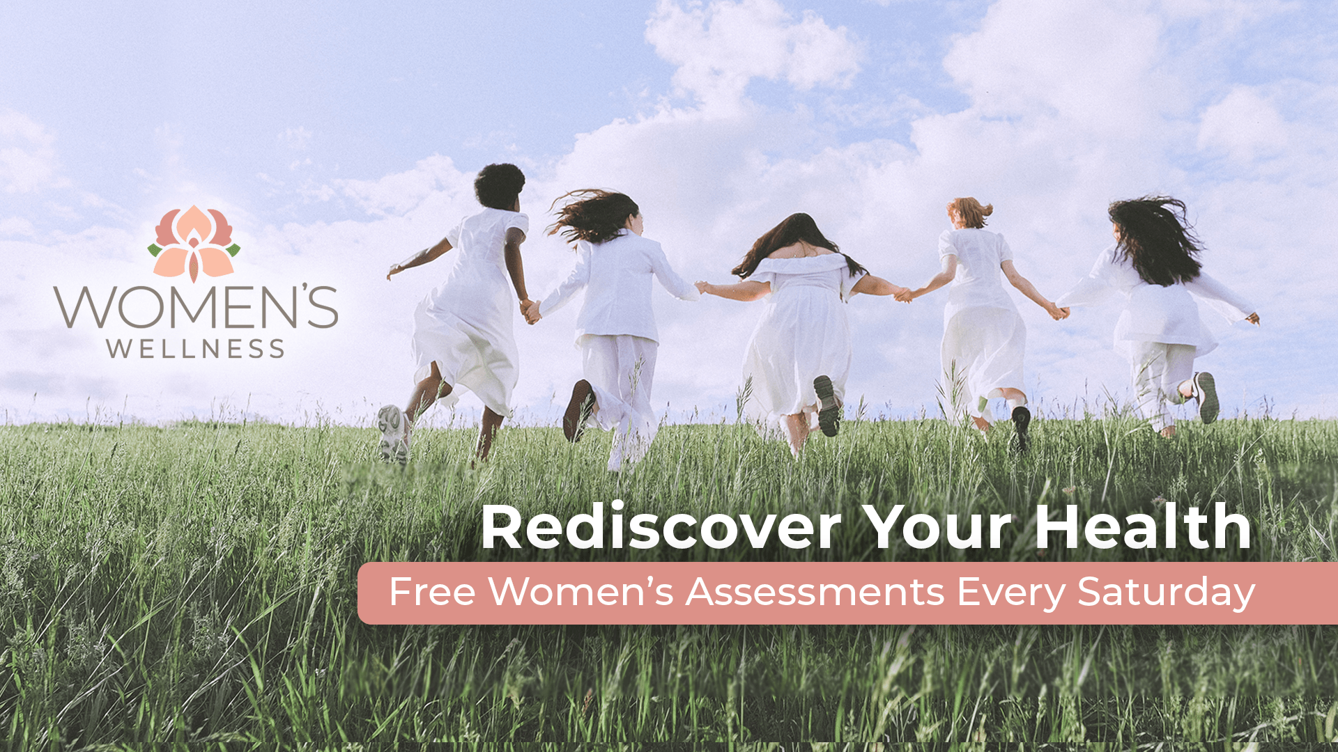 a group of women are running through a grassy field holding hands .