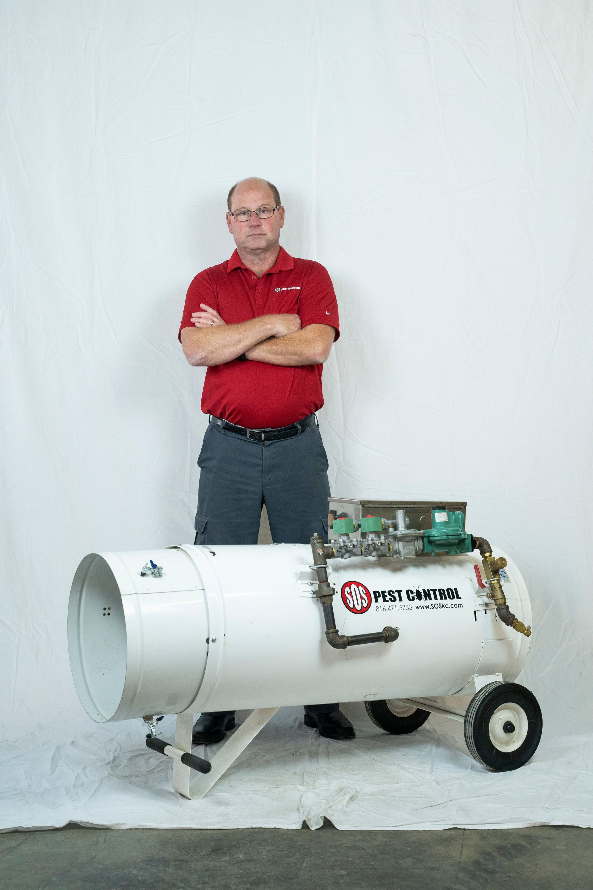 Professional photograph of SOS Pest Control owner standing by his equipment.
