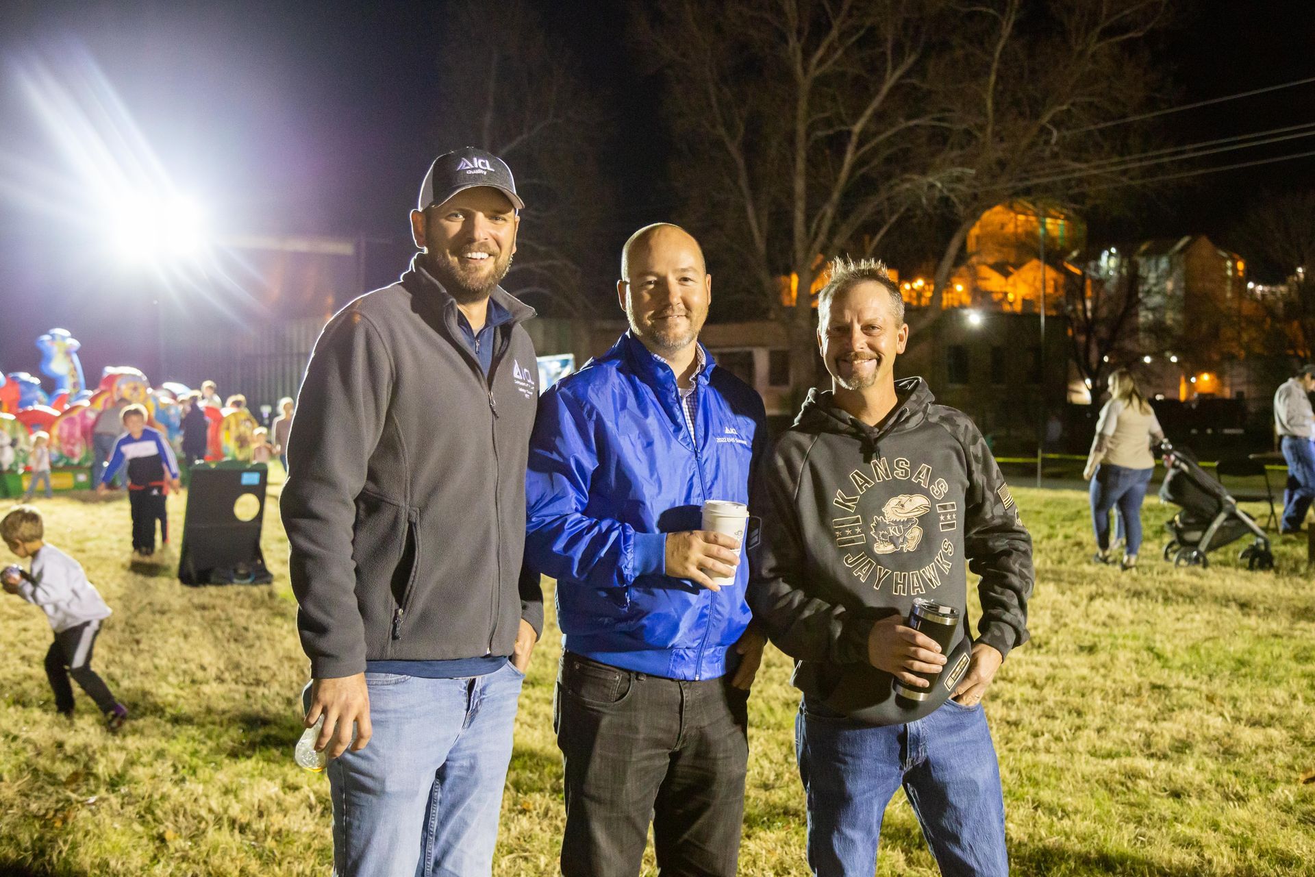 Professional photograph of 3 men standing outside at an evening party.