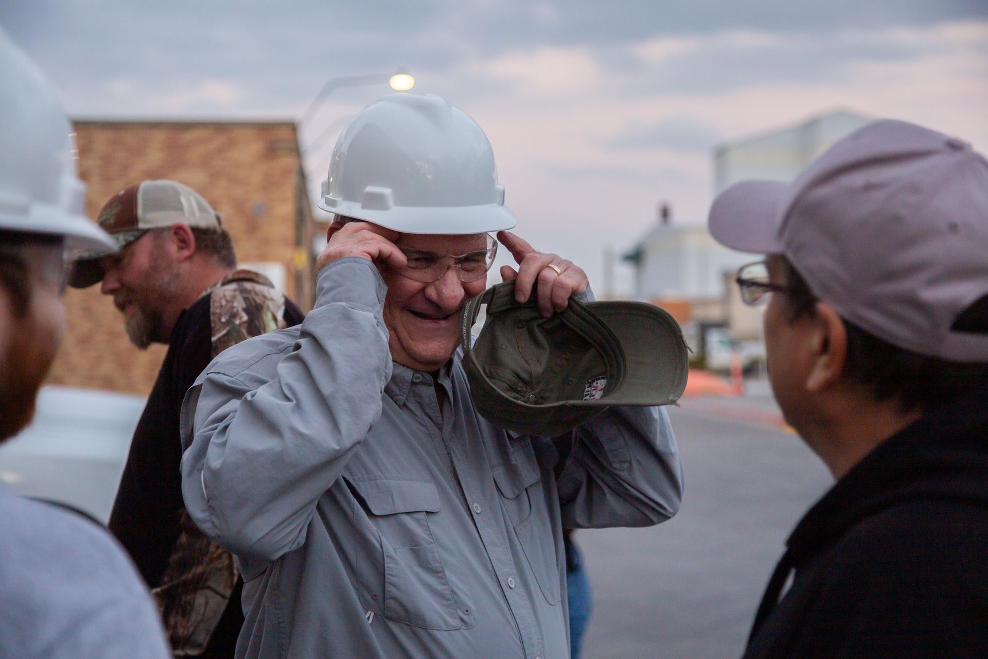 Professional photograph of men standing outside in hard hats.
