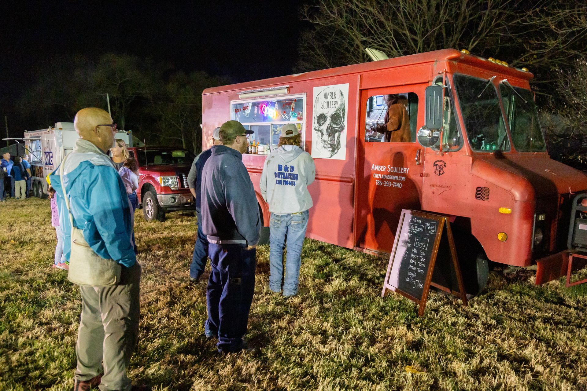 Professional photograph of of people standing in line at a food truck.