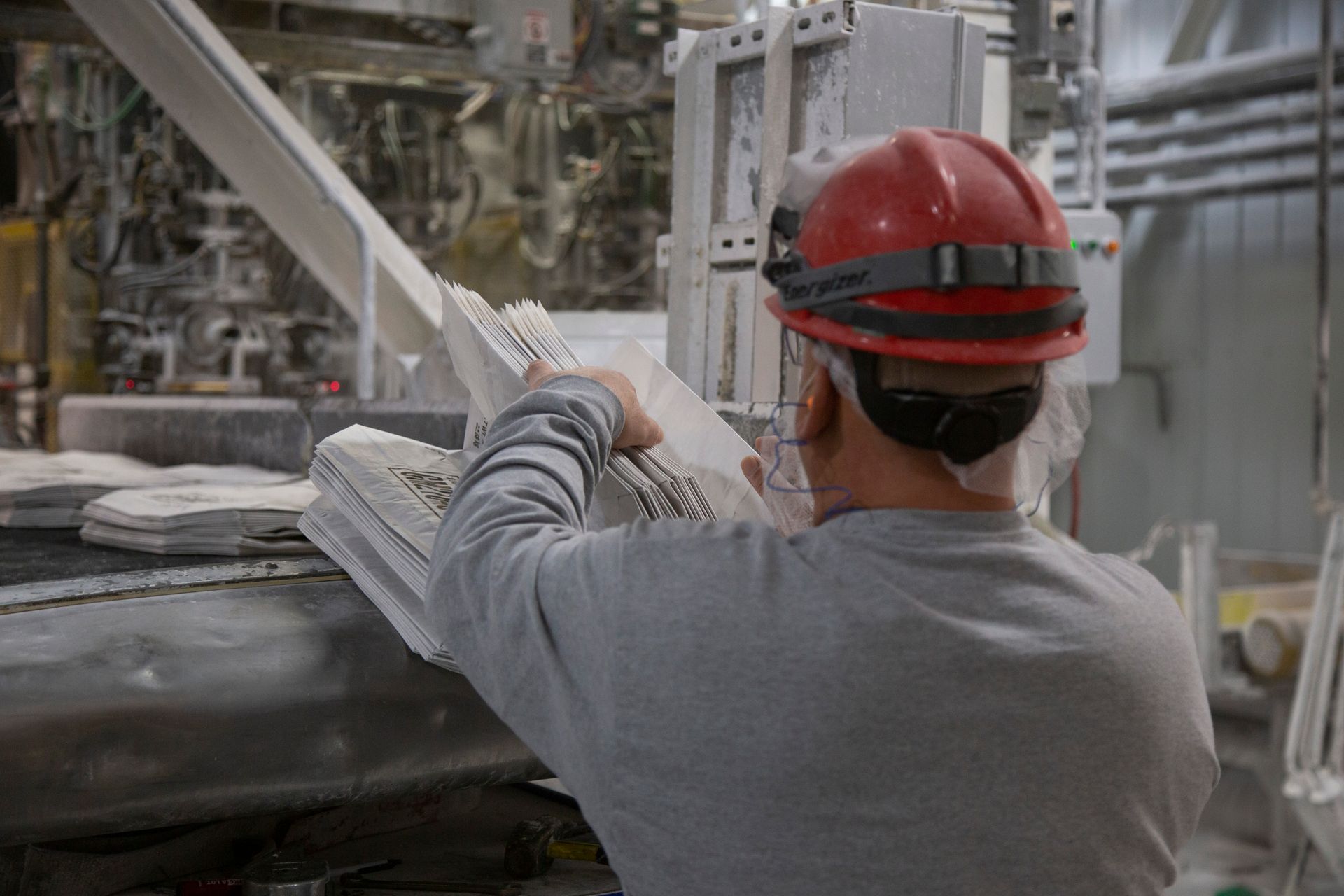 Professional photograph of a in a hard hat looking through a book.