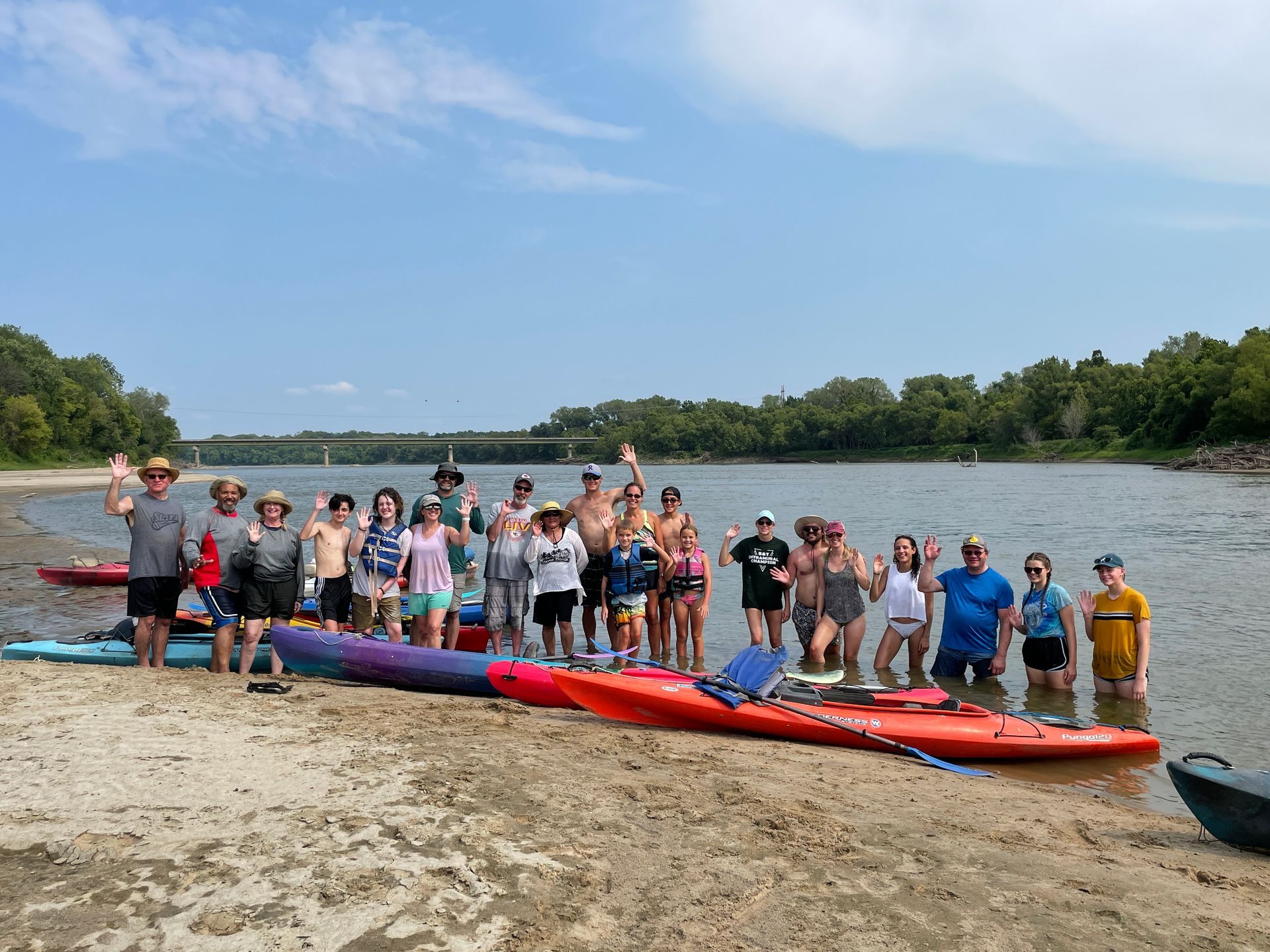 Professional photograph of a group of people standing next to a river.