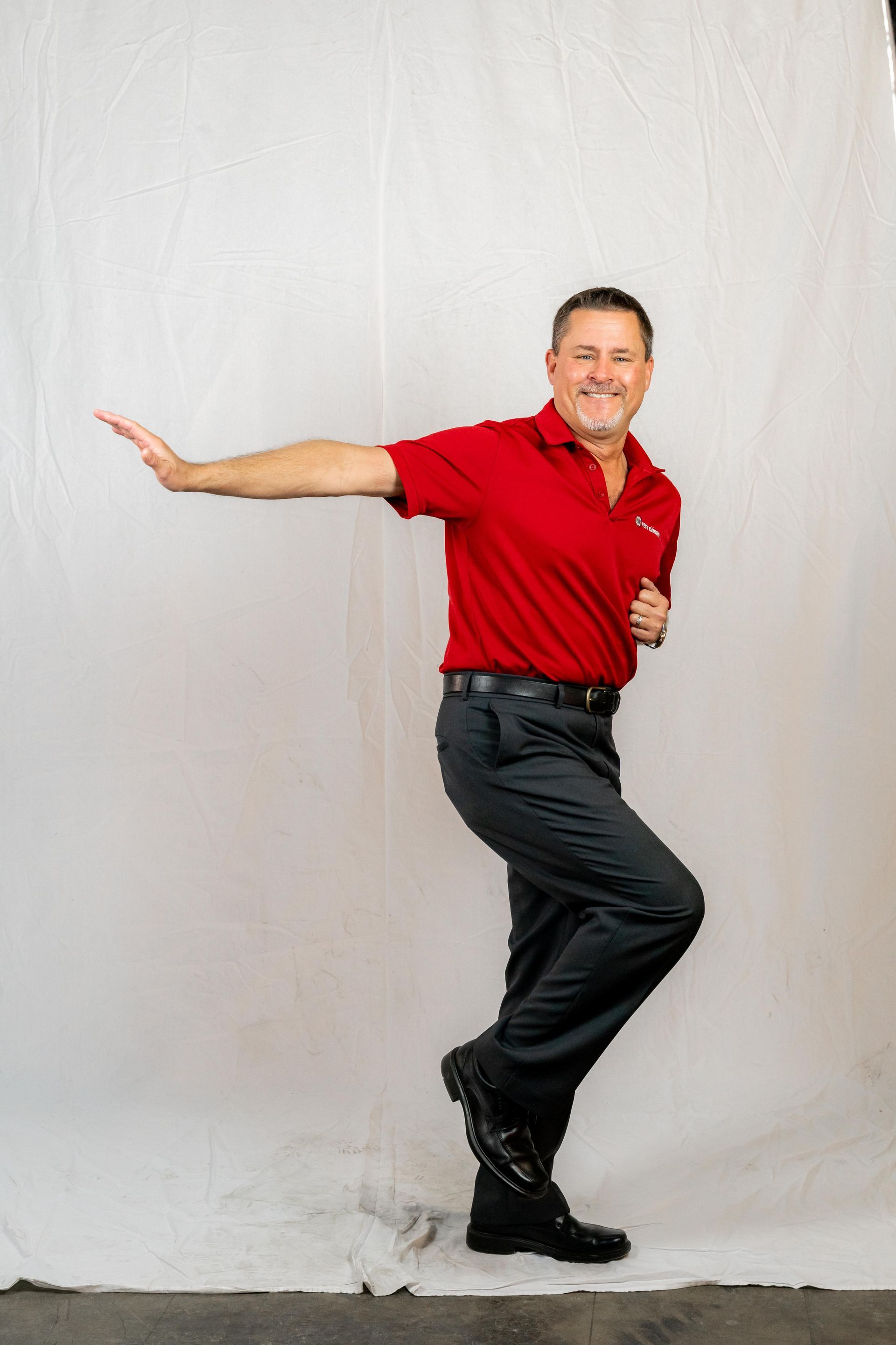 Professional photograph of an employee of SOS Pest Control taken by KMG. He is striking a funny pose.