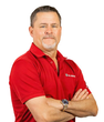 a man in a red shirt is standing with his arms crossed
