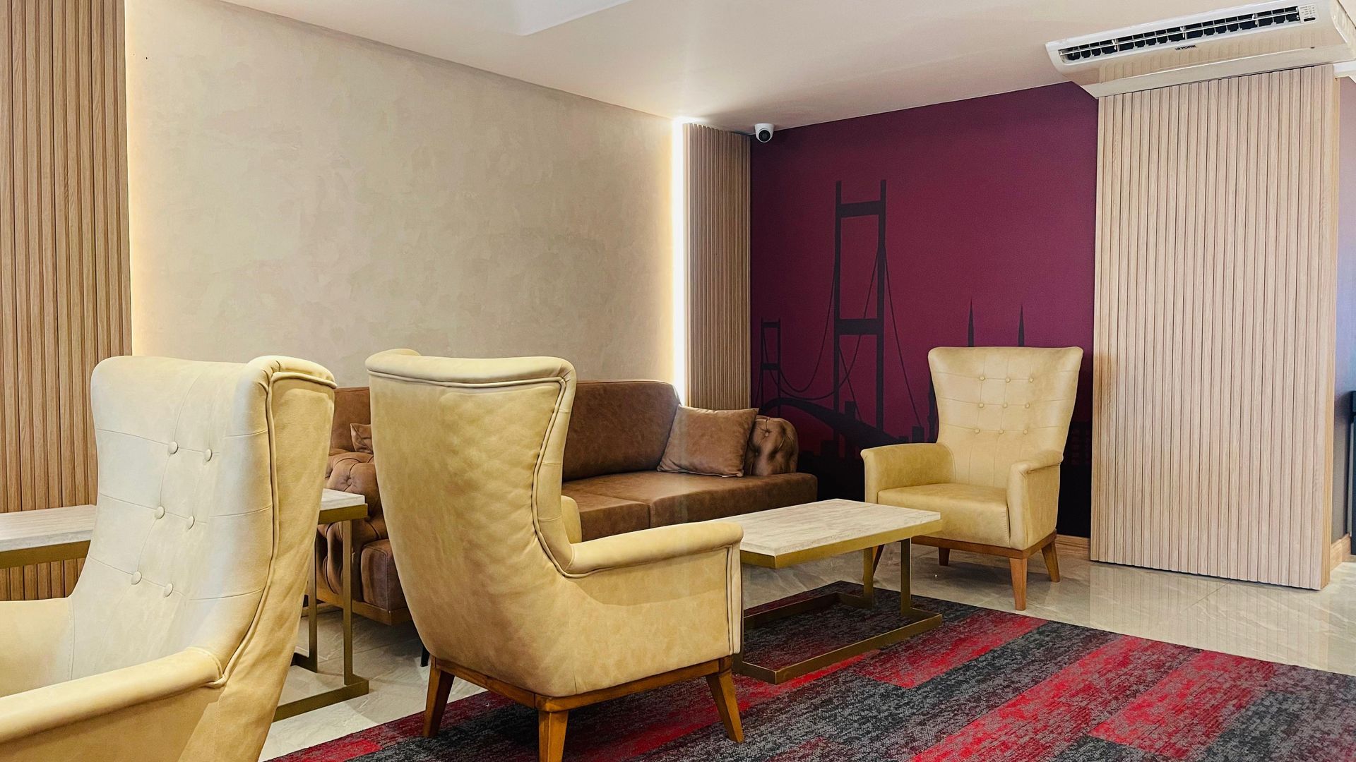 A living room with a couch , chairs , and a rug.