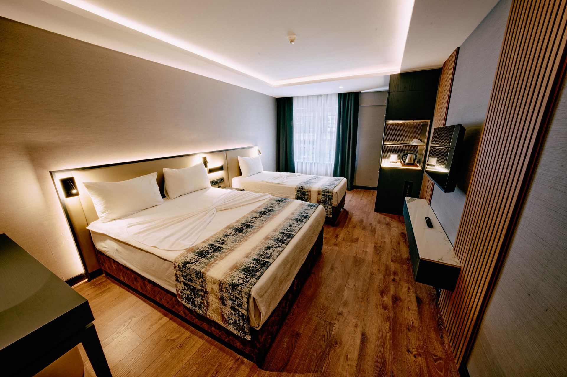 A hotel room with two beds and a desk