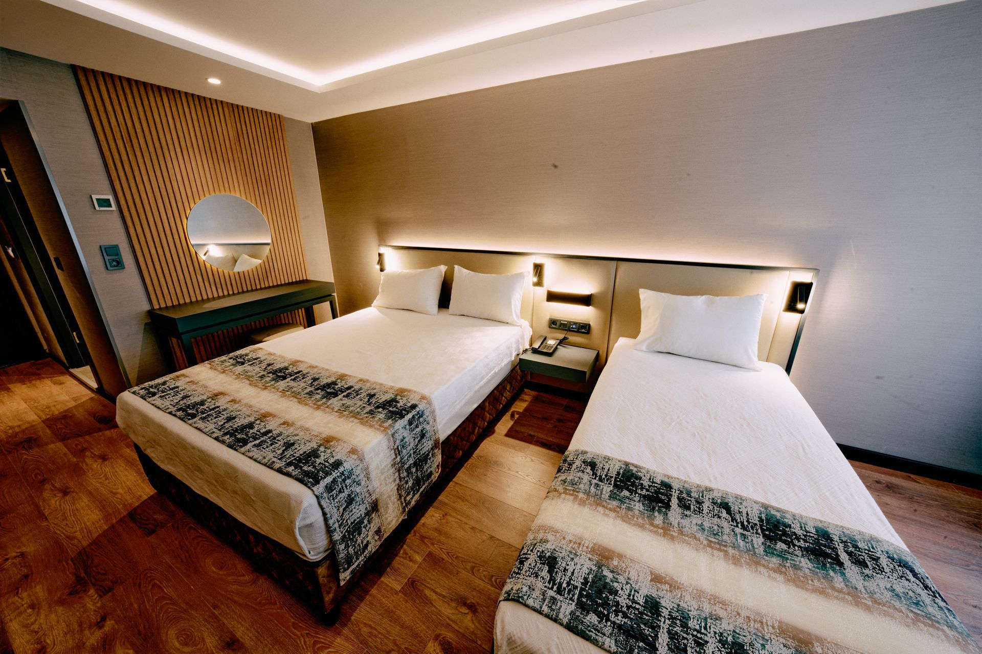 A hotel room with two beds and a mirror.