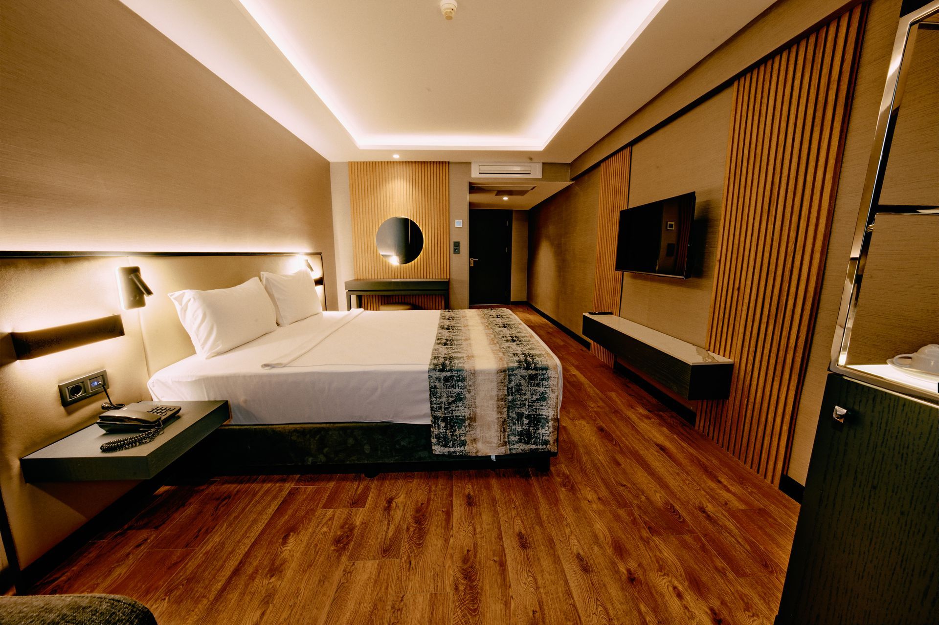 A hotel room with a large bed and a flat screen tv